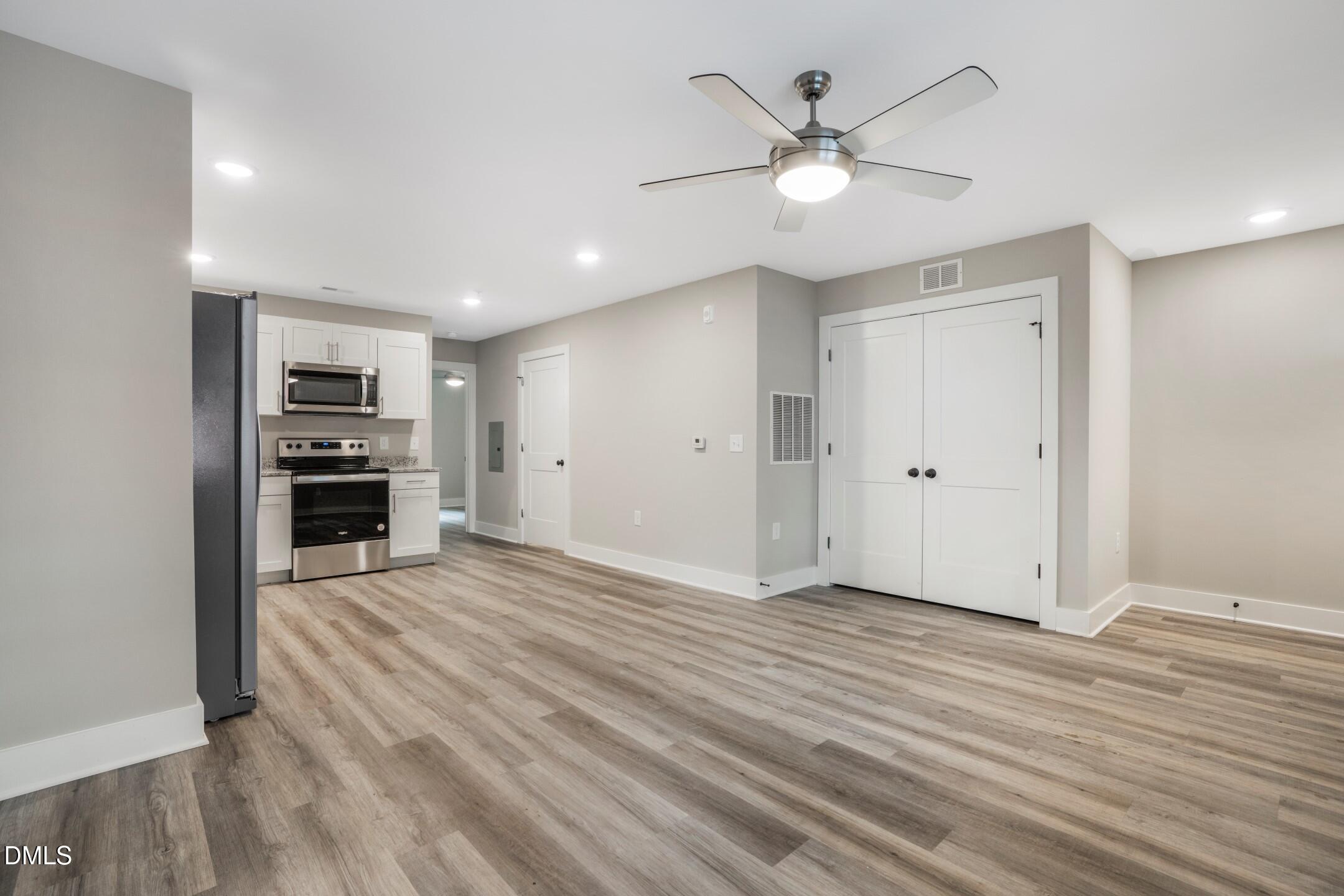 303 Linwood Street, Unit 302 Apex, NC 27502 - Photo 11 of 19 a view of an empty room with wooden floor and a ceiling fan