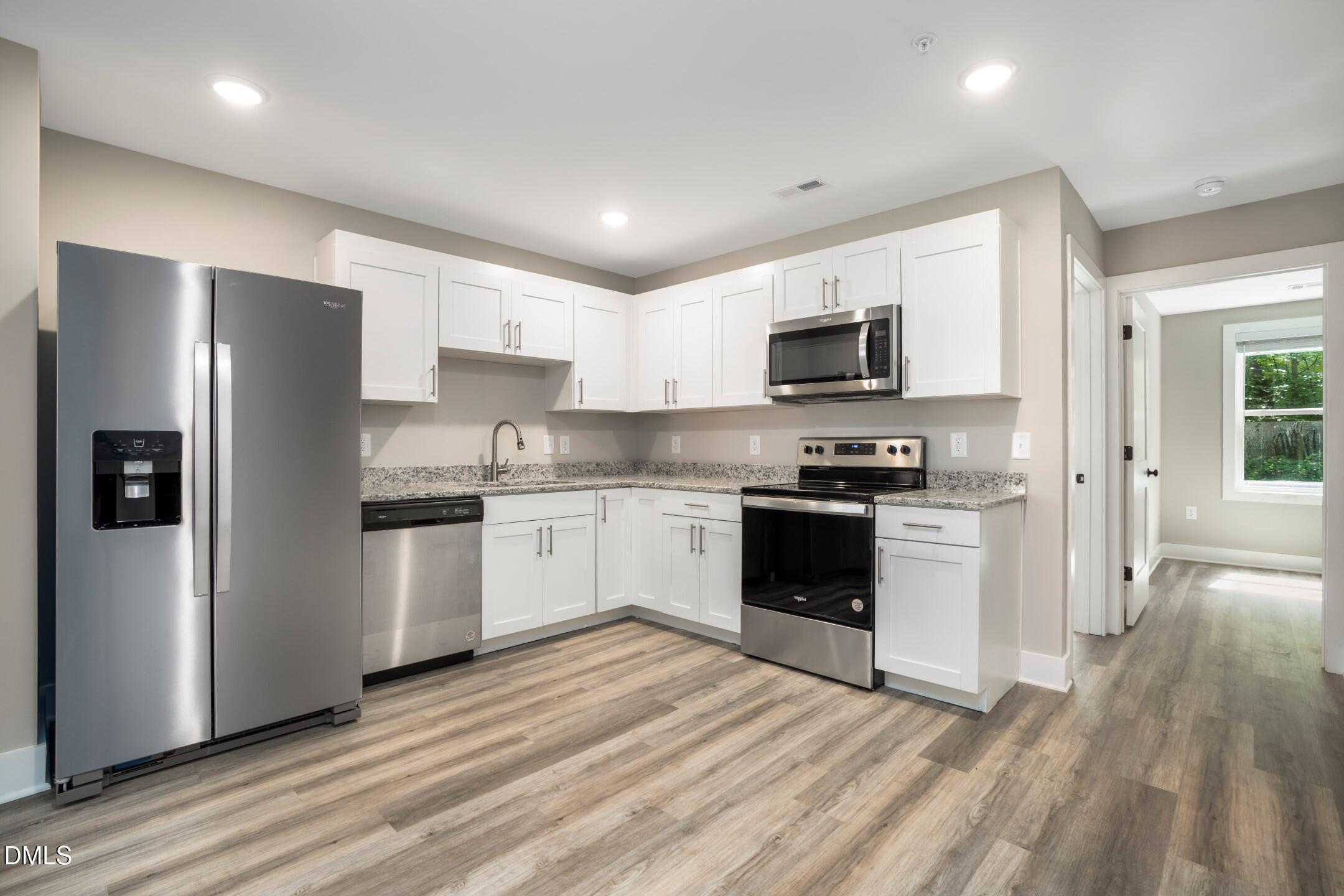 303 Linwood Street, Unit 302 Apex, NC 27502 - Photo 13 of 19 a kitchen with granite countertop a refrigerator stove top oven and sink