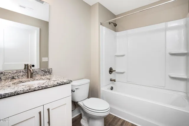 a bathroom with a granite countertop sink a toilet and a bathtub