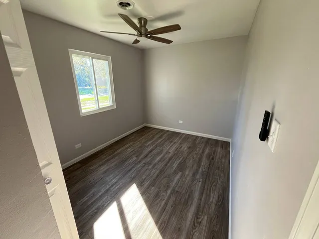 a view of hallway with window and a ceiling fan