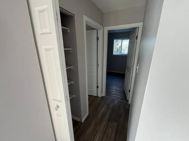 a view of a hallway with wooden floor and staircase