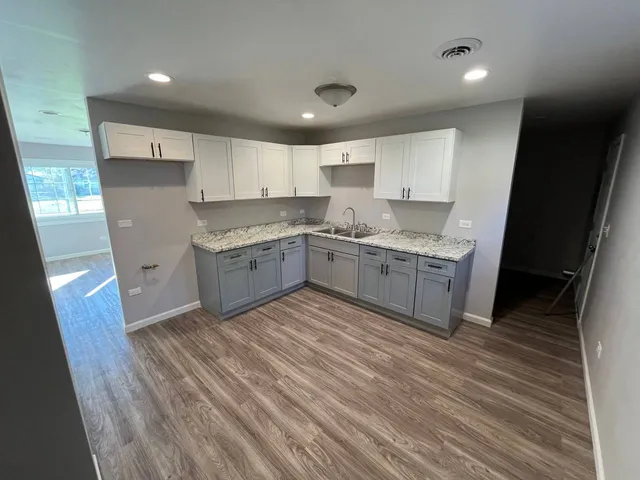 a kitchen with a sink window and cabinets