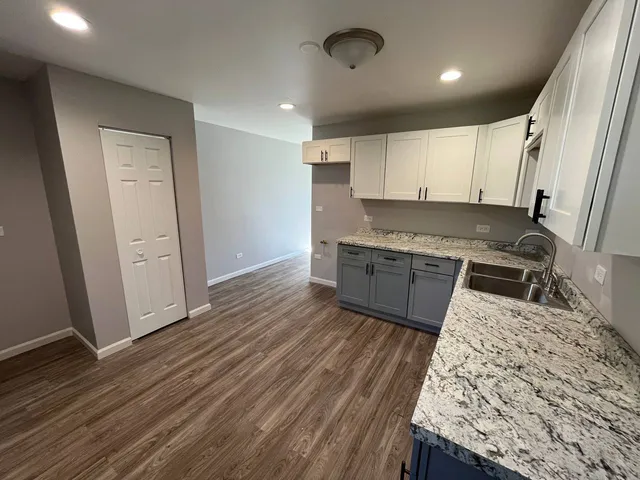 a kitchen with granite countertop wooden floors and white appliances