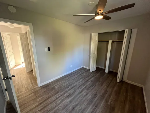a view of a livingroom with wooden floor and a ceiling fan