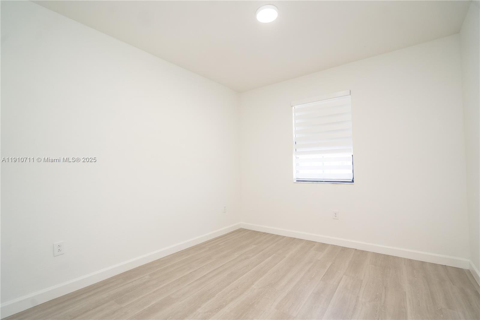 11374 Southwest 254th Terrace Homestead, FL 33032 - Photo 27 of 51 a view of an empty room with wooden floor and a window