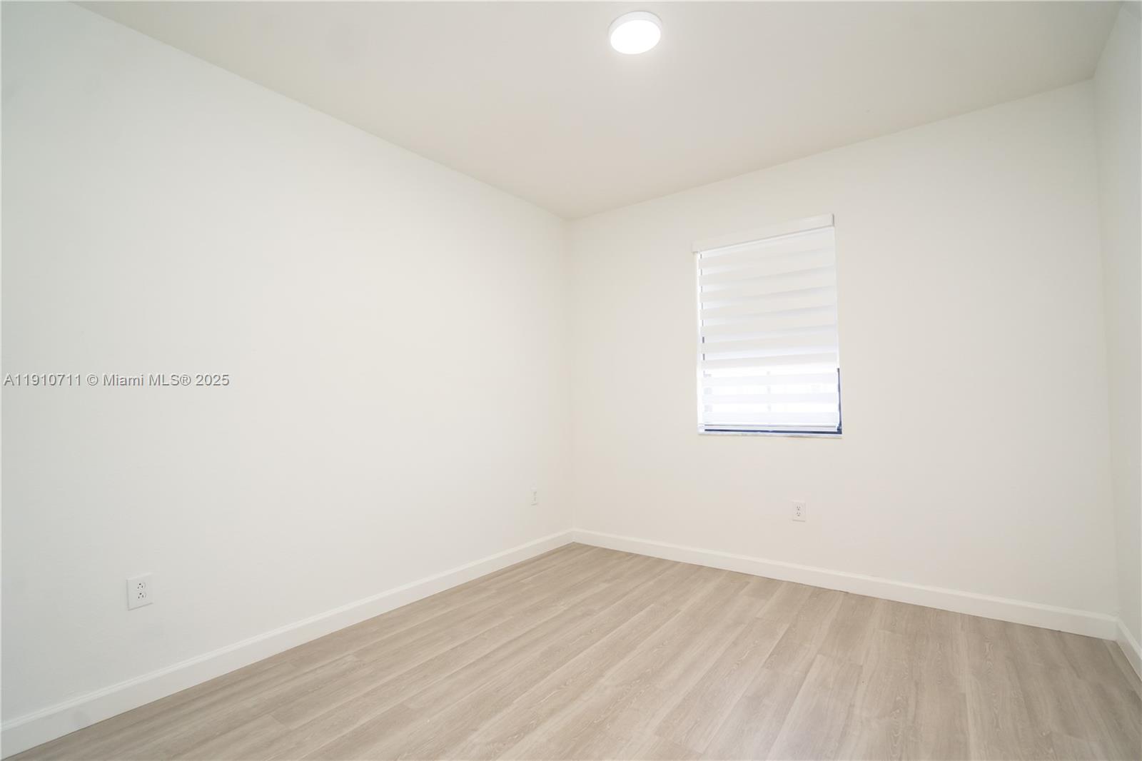 11374 Southwest 254th Terrace Homestead, FL 33032 - Photo 28 of 51 a view of an empty room with wooden floor and a window