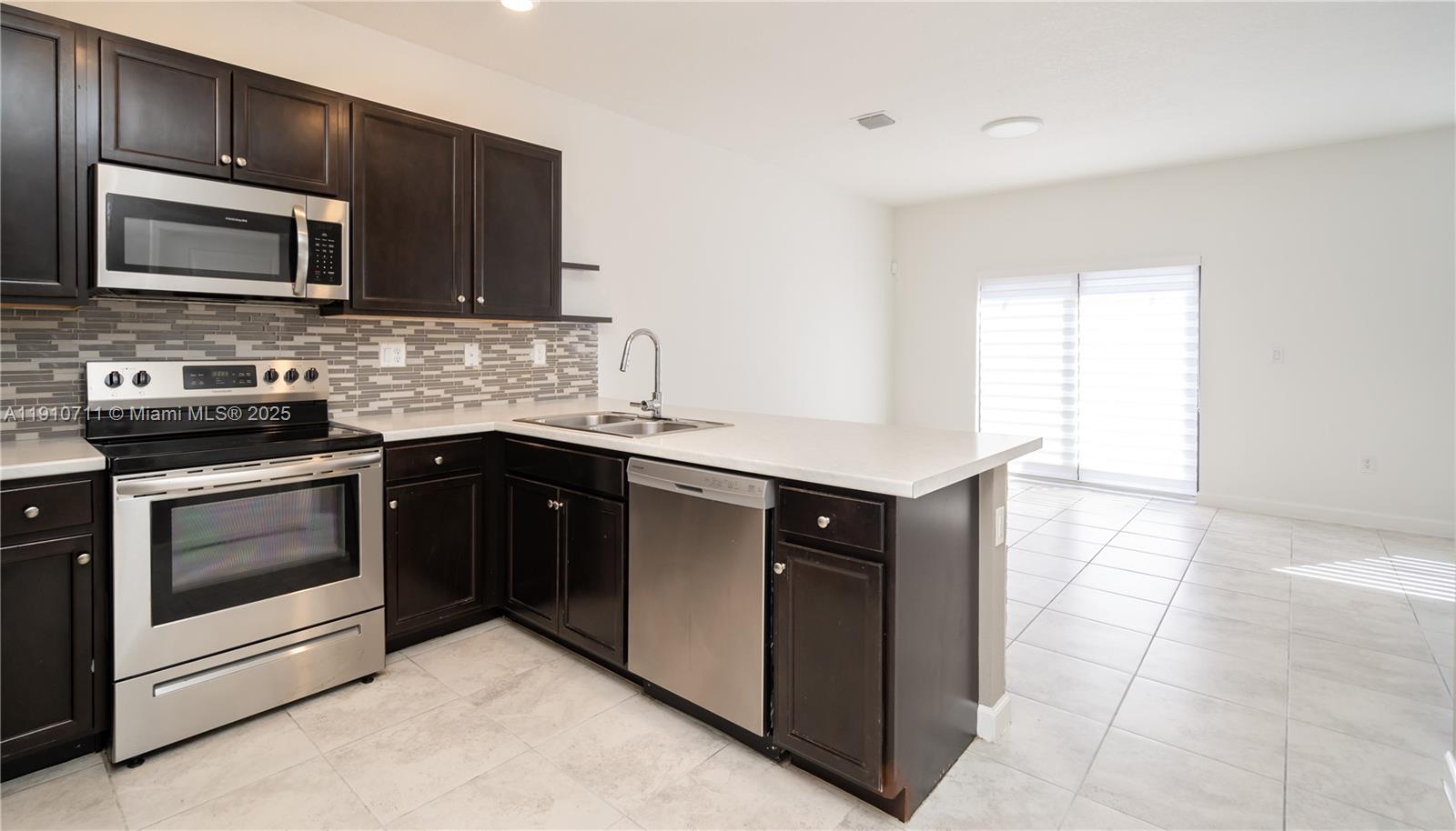 11374 Southwest 254th Terrace Homestead, FL 33032 - Photo 4 of 51 a kitchen with a sink stove and microwave