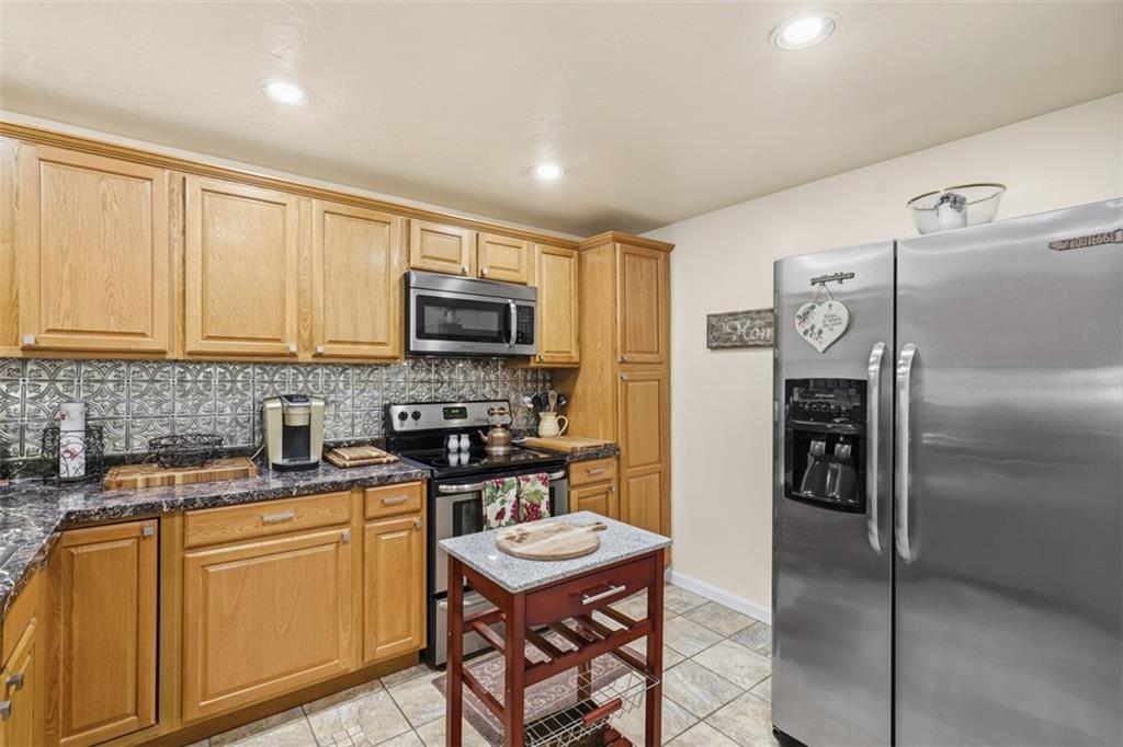5301 Ranchview Drive Pittsburgh, PA 15236 - Photo 17 of 44 a kitchen with stainless steel appliances granite countertop a refrigerator a stove a sink a dining table and chairs