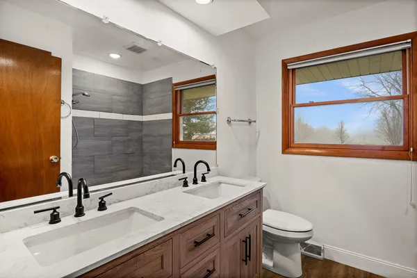 a bathroom with a toilet sink and mirror