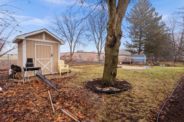a view of a house with backyard and trees