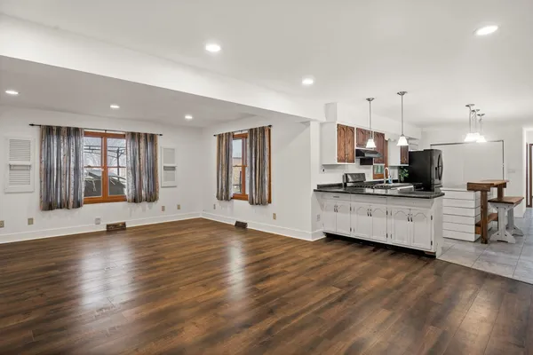 a view of kitchen with refrigerator and wooden floor