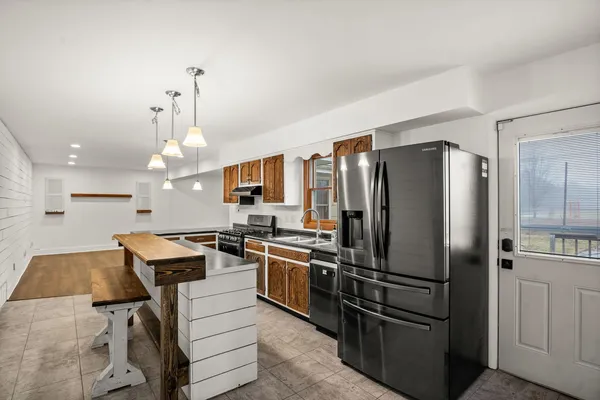 a kitchen with kitchen island a counter top space stainless steel appliances and cabinets