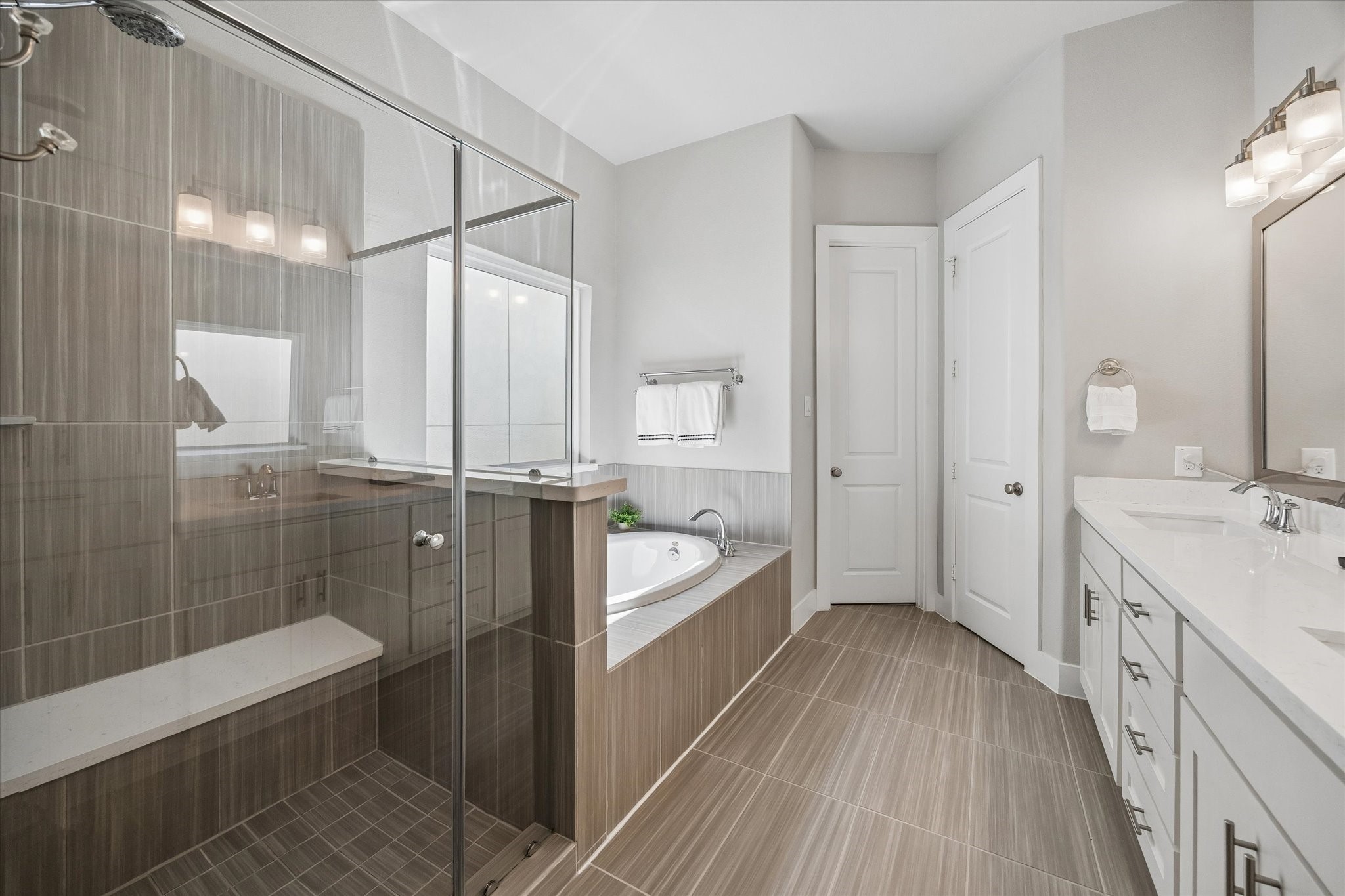 1309 West 24th Street, Unit B Houston, TX 77008 - Photo 19 of 22 Luxurious primary bath with soaking tub and oversized shower with bench.