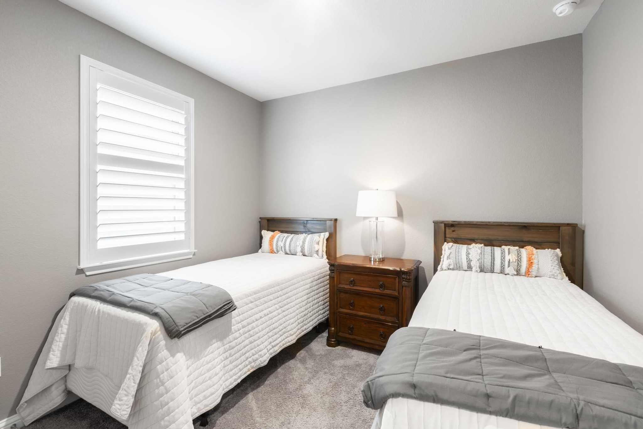 7801 Frida Bend Austin, TX 78744 - Photo 18 of 26 A well-lit bedroom features plush carpeting and a bright window with elegant plantation shutters.