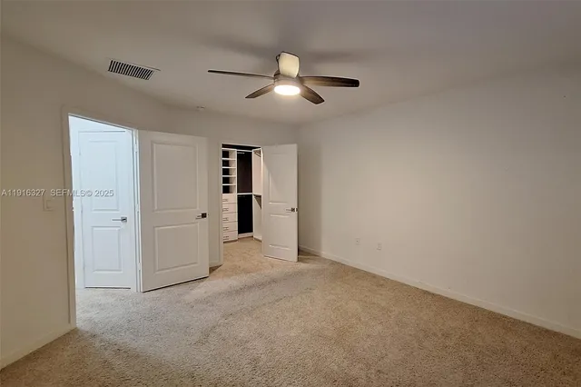 a view of a livingroom with a ceiling fan and window