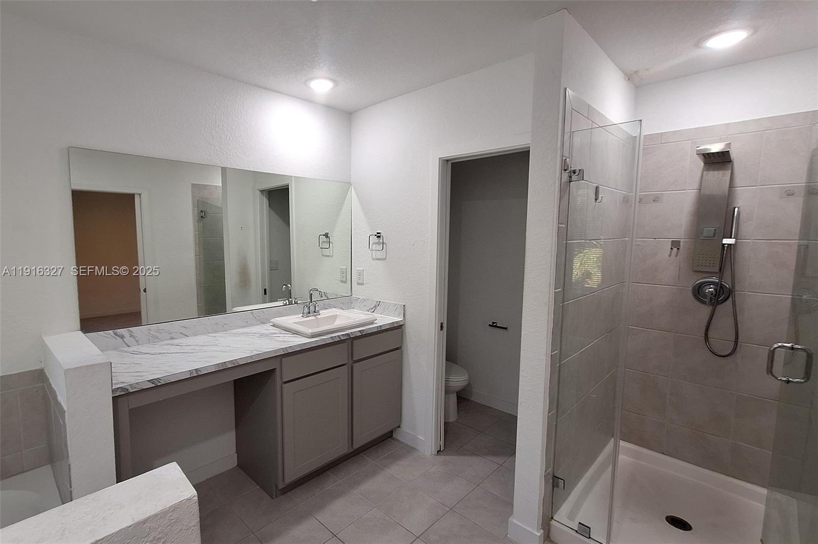 1325 Northwest 208th Street Miami Gardens, FL 33169 - Photo 17 of 38 a bathroom with a granite countertop sink a toilet and shower