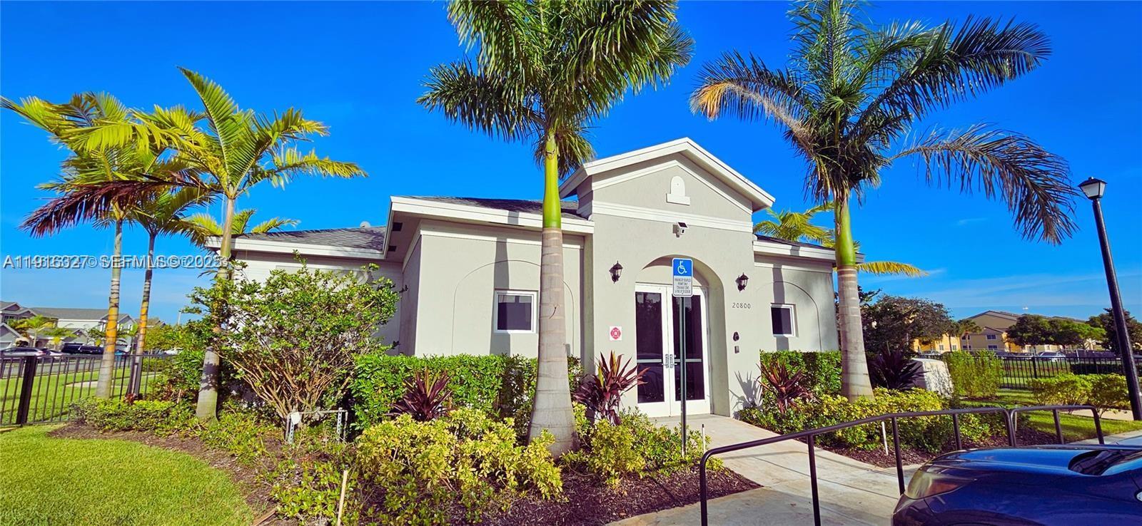 1325 Northwest 208th Street Miami Gardens, FL 33169 - Photo 38 of 38 a front view of a house with a yard and potted plants