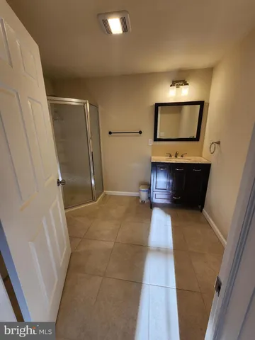 a bathroom with a granite countertop sink a toilet and shower