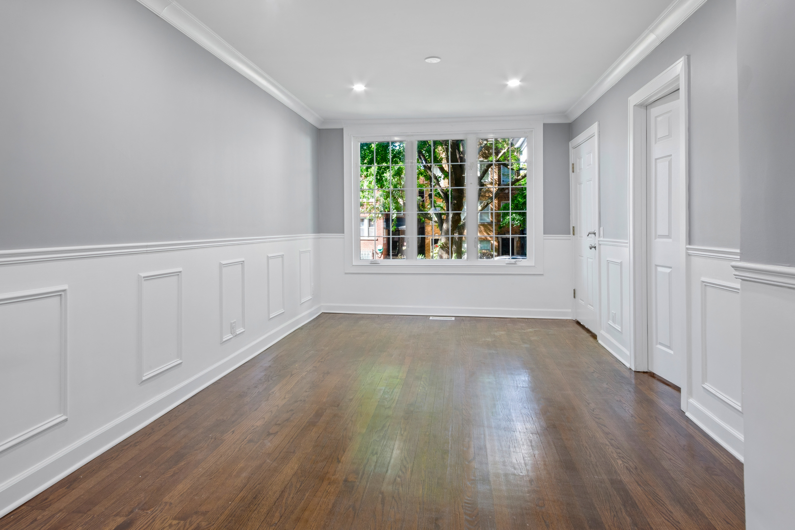 4251 North Lawndale Avenue, Unit 2 Chicago, IL 60618 - Photo 4 of 20 an empty room with wooden floor and windows