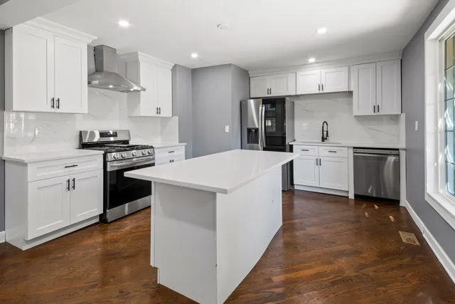 a kitchen with stainless steel appliances a sink stove refrigerator and cabinets