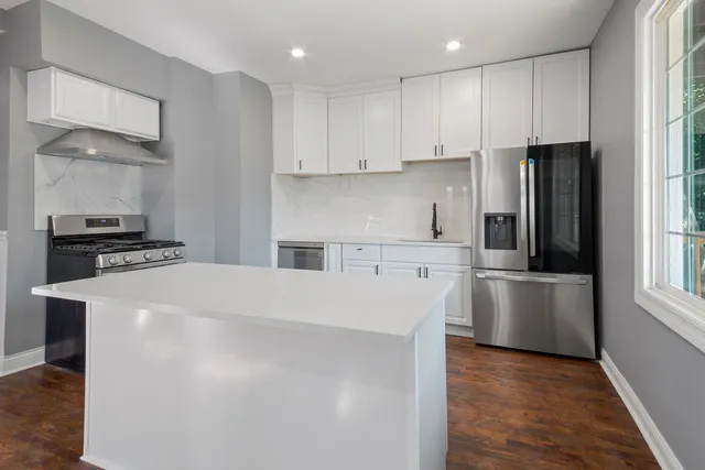 a kitchen with stainless steel appliances a refrigerator and a stove top oven