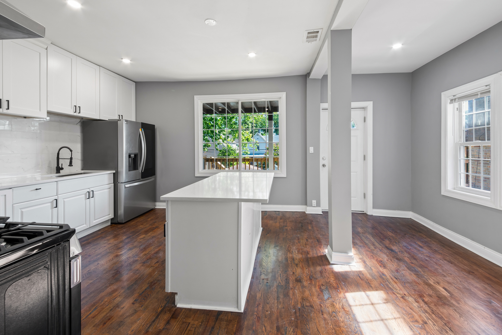 4251 North Lawndale Avenue, Unit 2 Chicago, IL 60618 - Photo 7 of 20 a kitchen with stainless steel appliances granite countertop a refrigerator a sink dishwasher a stove and white countertops with wooden floor
