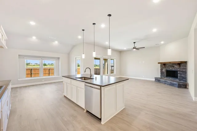a kitchen with stainless steel appliances granite countertop a stove and a wooden floor