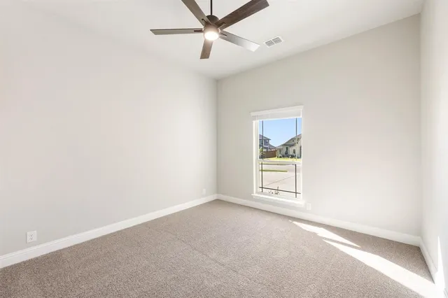 an empty room with a window and ceiling fan