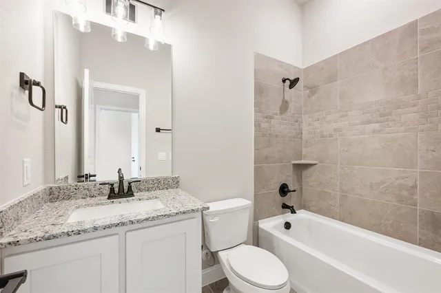 a bathroom with a granite countertop sink a toilet and bathtub