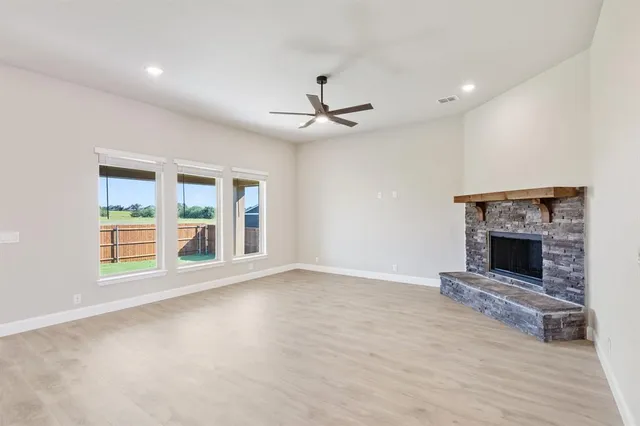 a view of an empty room with a fireplace and a window