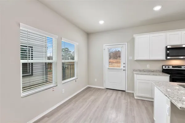 a view of an empty room and chandelier fan