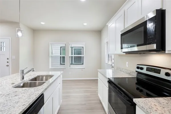 a bathroom with a granite countertop double vanity sink and mirror