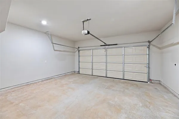 an empty room with chandelier fan and windows