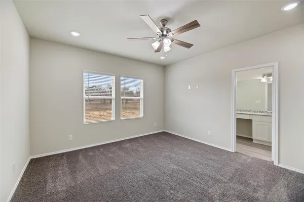 a view of a livingroom with a chandelier fan and windows
