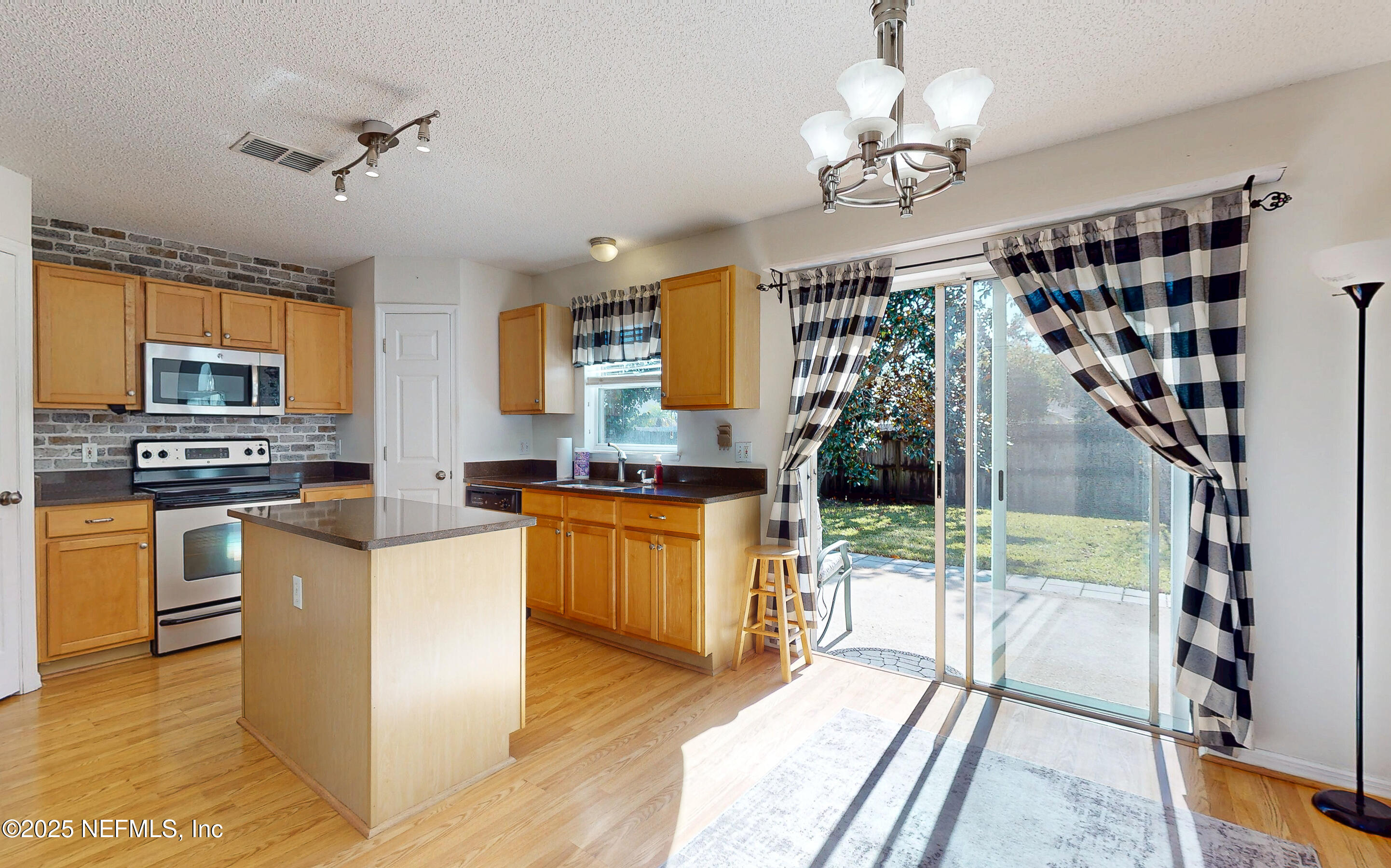 3031 Valkyrie Road Middleburg, FL 32068 - Photo 2 of 36 a kitchen with stainless steel appliances granite countertop a stove and a view of living room
