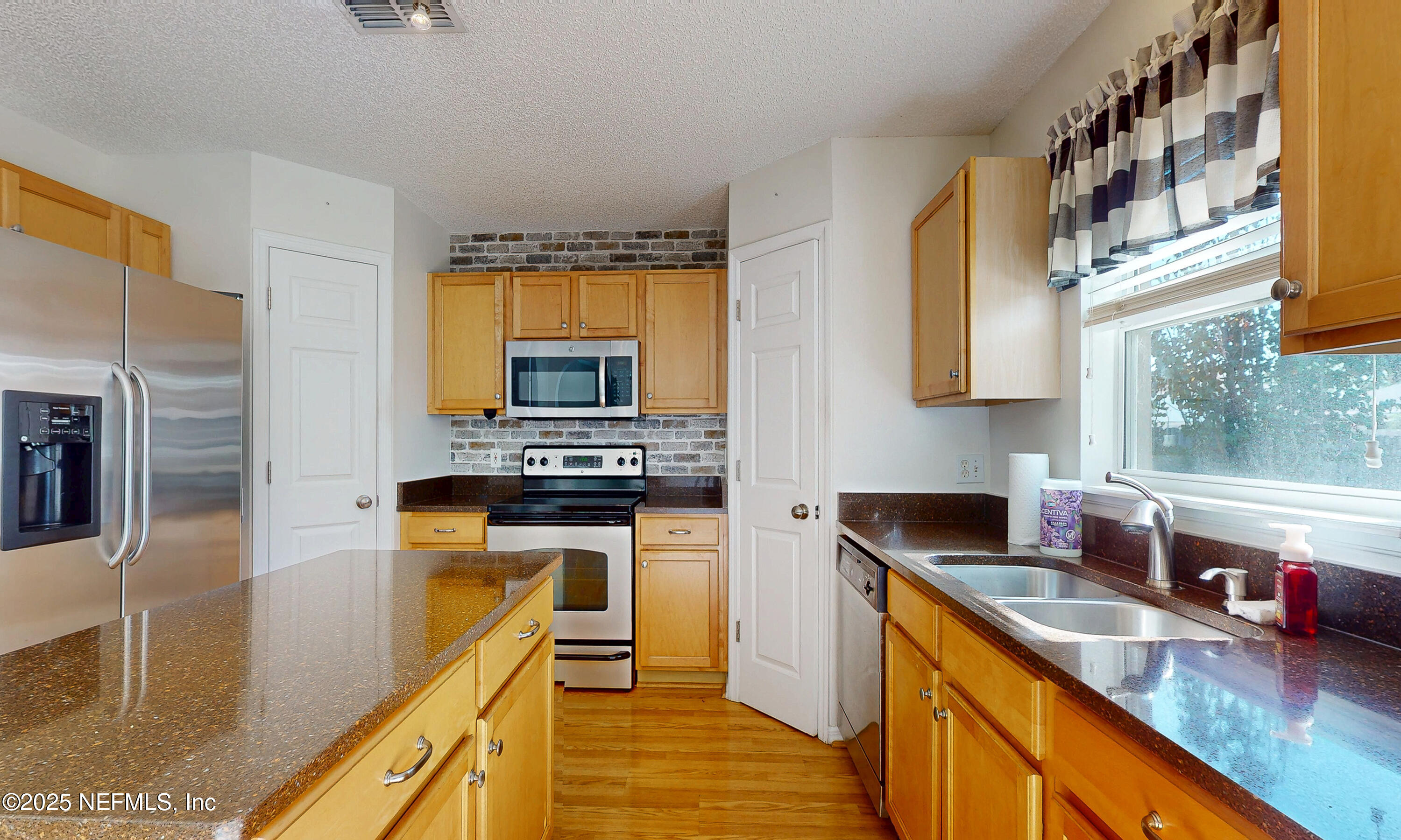 3031 Valkyrie Road Middleburg, FL 32068 - Photo 6 of 36 a kitchen with stainless steel appliances granite countertop a sink stove and refrigerator