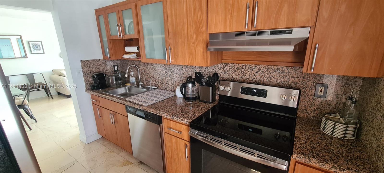 1300 Alton Road, Unit 3D Miami Beach, FL 33139 - Photo 8 of 11 a kitchen with stainless steel appliances granite countertop a stove a sink and a microwave