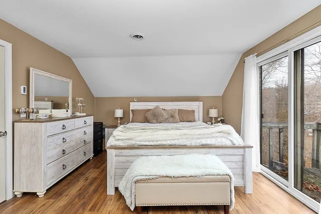 a bedroom with a bed and large windows