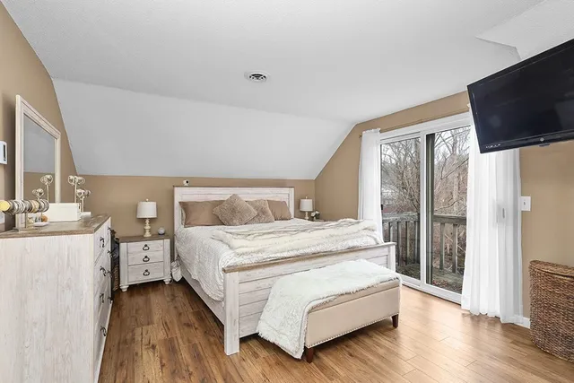 a spacious bedroom with a bed and a flat screen tv