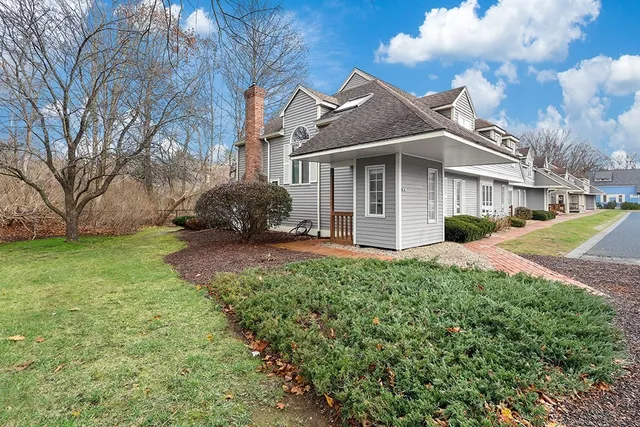 a front view of a house with a garden and trees