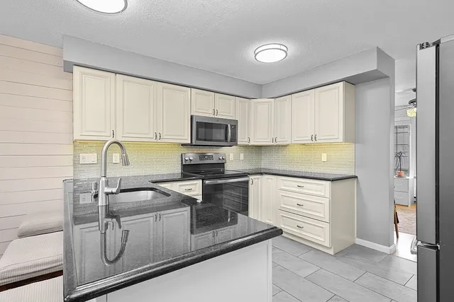 a kitchen with appliances a sink and cabinets