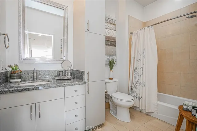 a bathroom with a granite countertop sink a toilet and a mirror