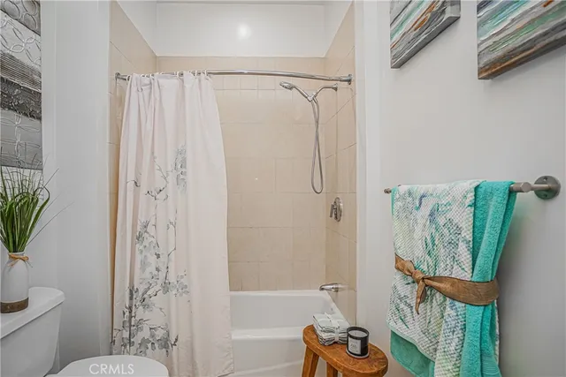 a bathroom with a shower curtain a sink and a toilet