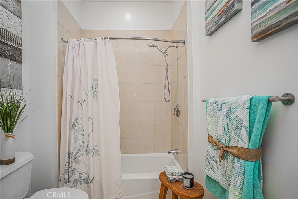 3810 Wilshire Boulevard, Unit 1409 Los Angeles, CA 90010 - Photo 14 of 41 a bathroom with a shower curtain a sink and a toilet