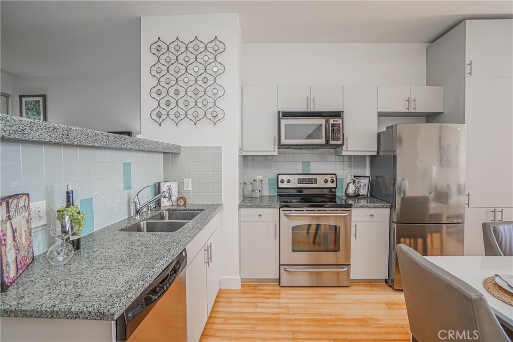 3810 Wilshire Boulevard, Unit 1409 Los Angeles, CA 90010 - Photo 22 of 41 a kitchen with stainless steel appliances granite countertop a sink stove and refrigerator