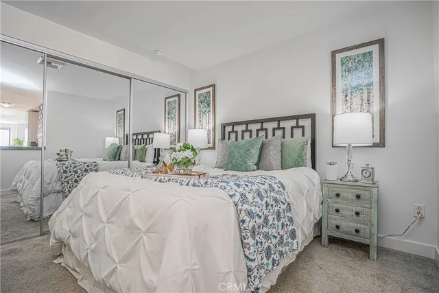 a bedroom with a bed and a lamp on dresser