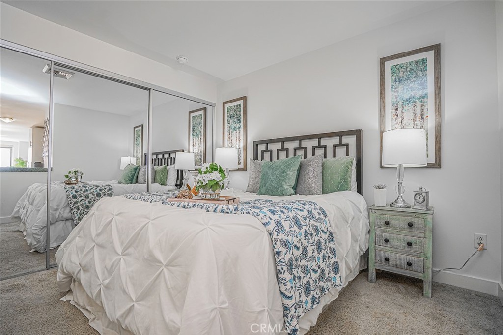 3810 Wilshire Boulevard, Unit 1409 Los Angeles, CA 90010 - Photo 9 of 41 a bedroom with a bed and a lamp on dresser