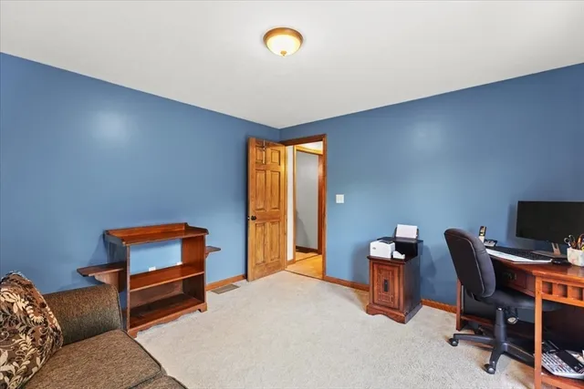 a bedroom with bed and a workspace