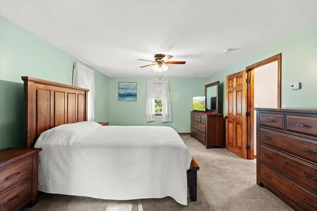 a spacious bedroom with a bed and a dresser