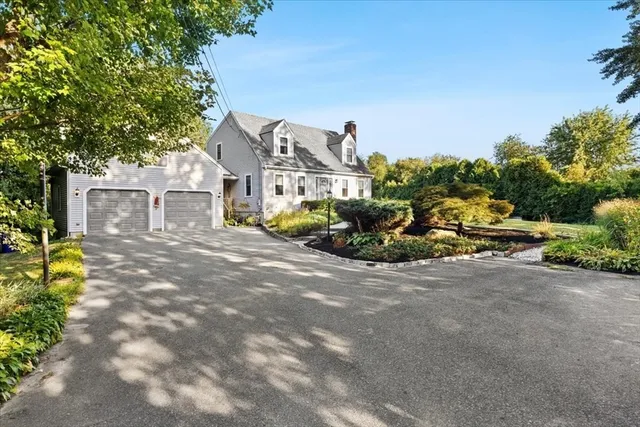 an aerial view of a residential houses with outdoor space and trees